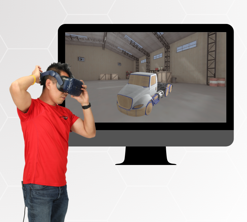 A man wearing a red shirt and jeans is using a virtual reality (VR) headset. In the background, a computer monitor displays a 3D-rendered simulation of a truck in a warehouse setting.