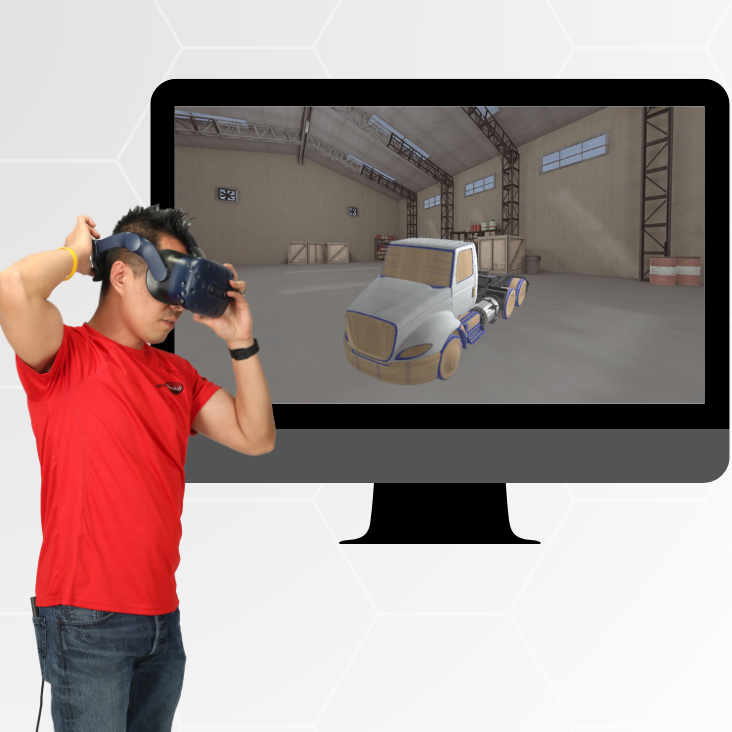 A man wearing a red shirt and jeans is using a virtual reality (VR) headset. In the background, a computer monitor displays a 3D-rendered simulation of a truck in a warehouse setting.